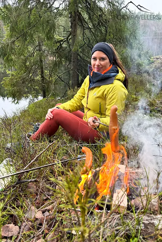 Reisebloggerin Biggi Bauer am Lagerfeuer mit einer Veggi-Bratwurst