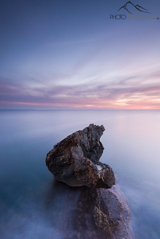 Beispiel Minimalismus: Ein Fels im Meer am Abend