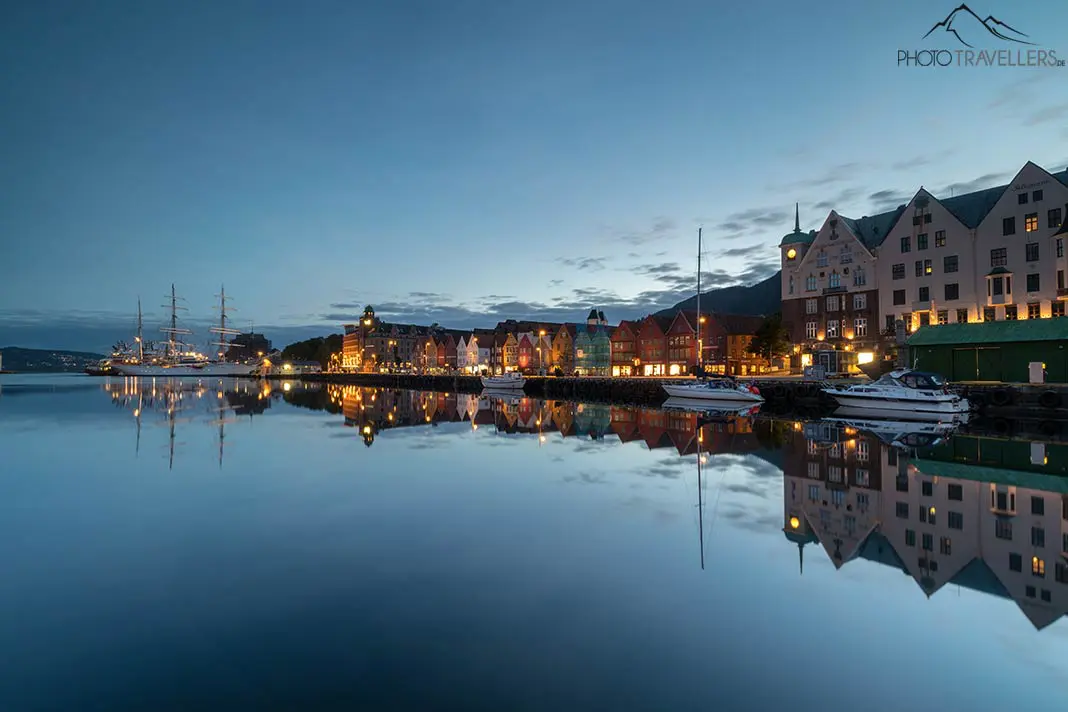 Die Spiegelung einer Ortschaft mit bunt erstrahlten Häusern in Norwegen im Wasser