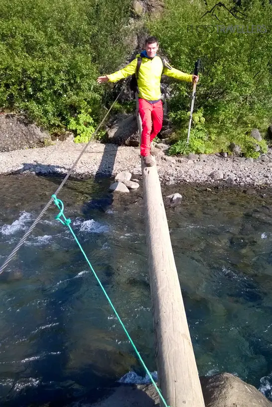 Flo balanciert auf einem Baumstamm über einem Fluss