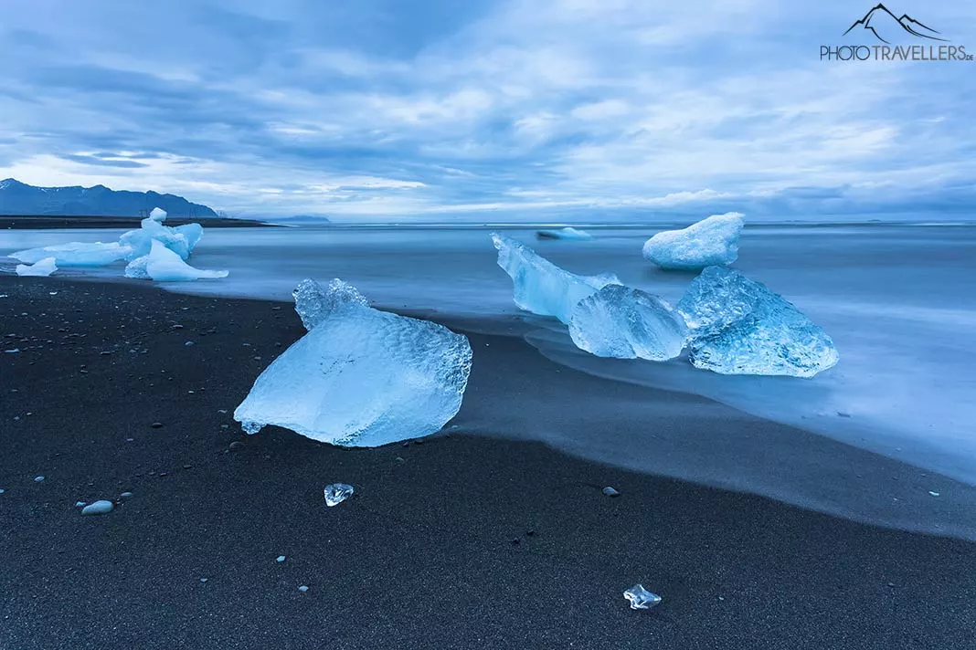 Eisschollen liegen auf einem schwarzen Strand in Island