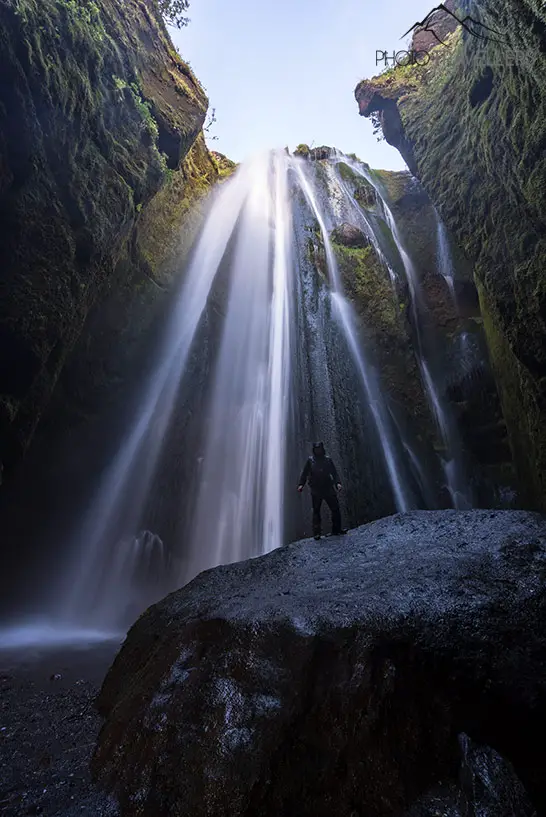Flo vor dem Wasserfall Gljúfrabúi in Island in einer Höhle