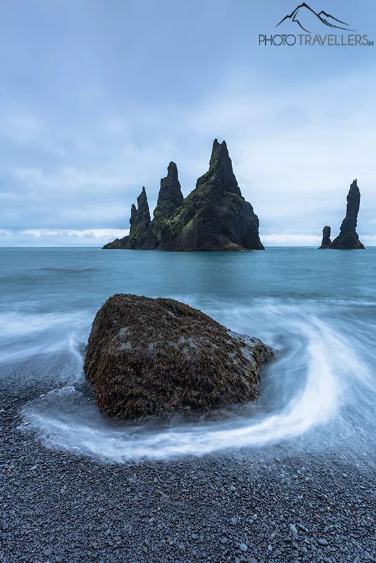 Die Felsen im Meer an der Küste von Reynisfjara in Island