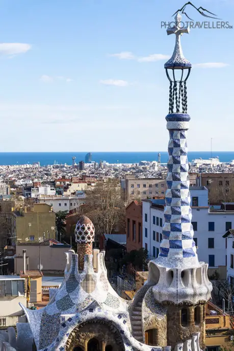 A tower in Park Güell in Barcelona with a view of the sea