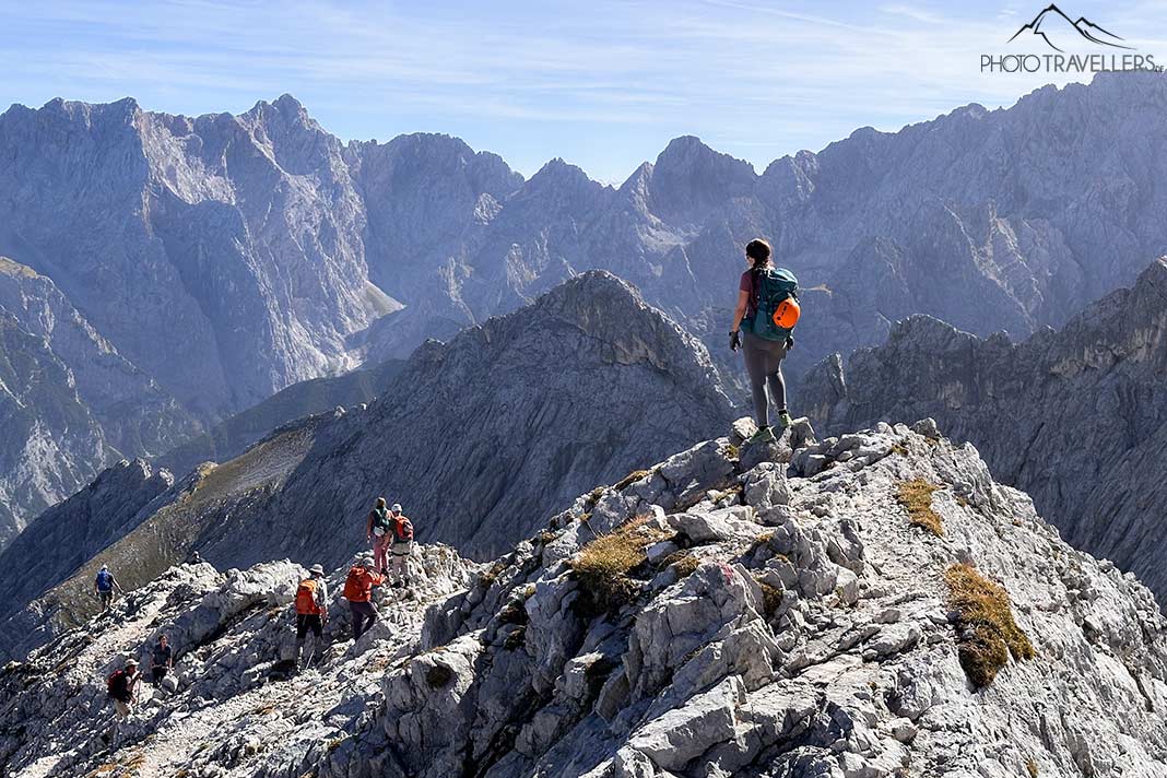 Reisebloggerin Biggi Bauer steht auf einem felsigen Hügel auf dem Ostgrat der Alpspitze und blickt in die Ferne