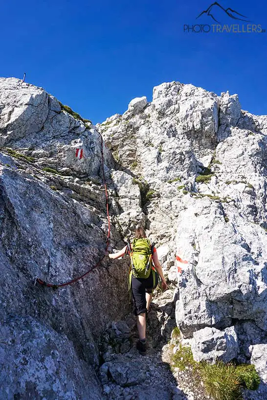 Reisebloggerin Biggi Bauer klettert ein seilversichertes Stück unterhalb des Guffert-Gipfels nach oben