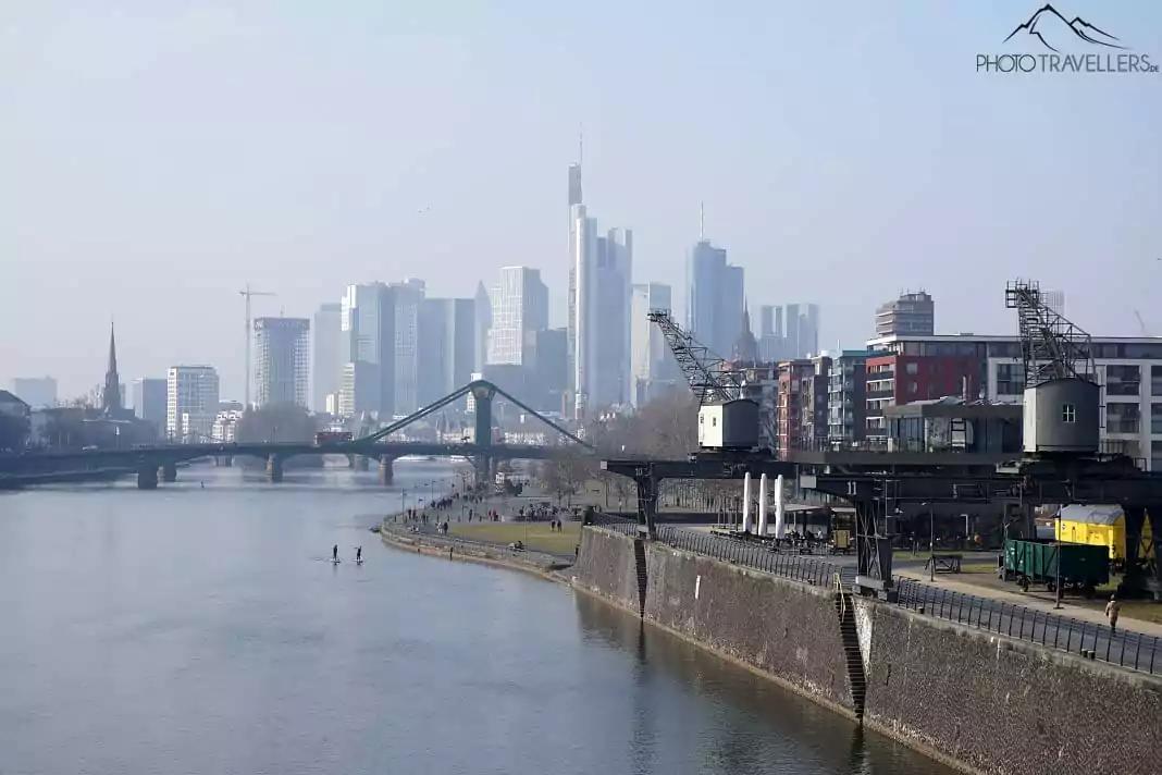 Der Blick auf die Skyline von Frankfurt mit Kränen am Main im Vordergrund