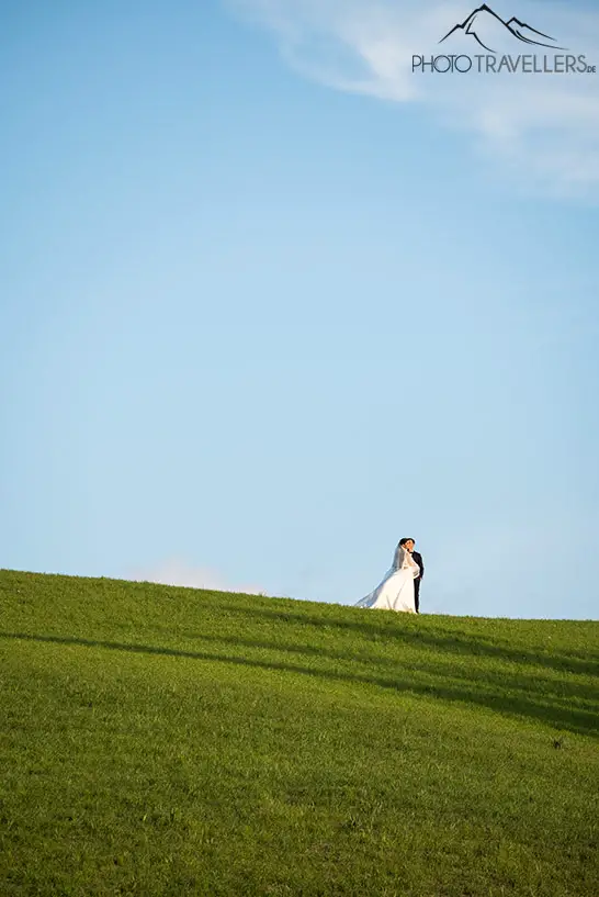 Ein Hochzeitspaar in grünen Feldern in der Toskana
