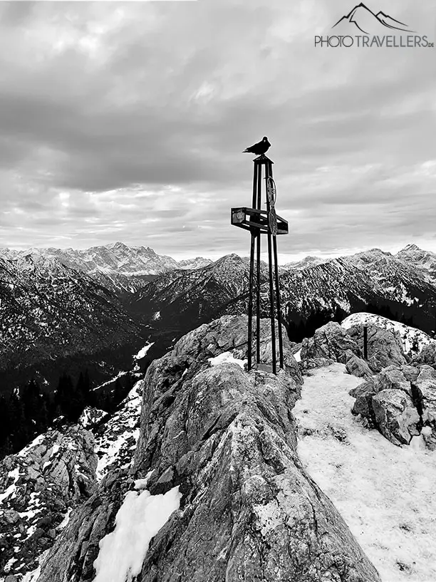 Ein Gipfelkreuz in den Alpen in schwarz-weiß bearbeitet