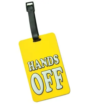 Ein gelber Kofferanhänger mit dem Spruch "Hands off"