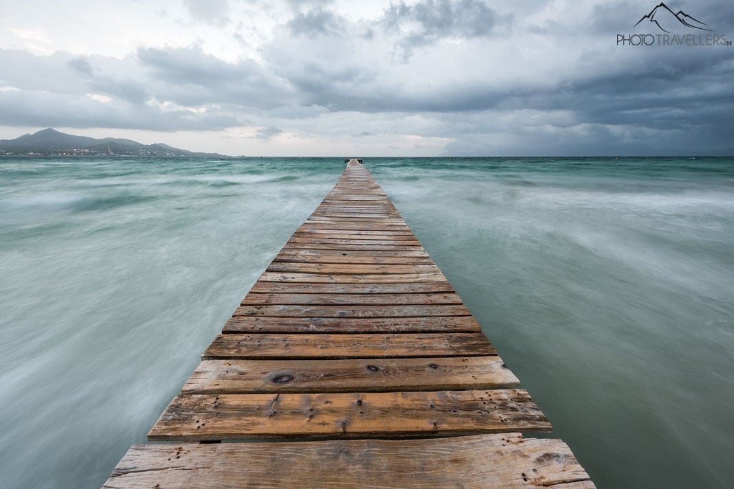 Ein langer Holzsteg an der Playa de Muro auf Mallorca