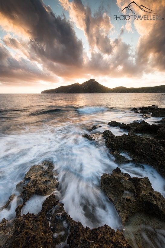 Der Blick vom Felsstrand in Sant Elm auf Mallorca auf die Dracheninsel Sa Dragonera am Abend