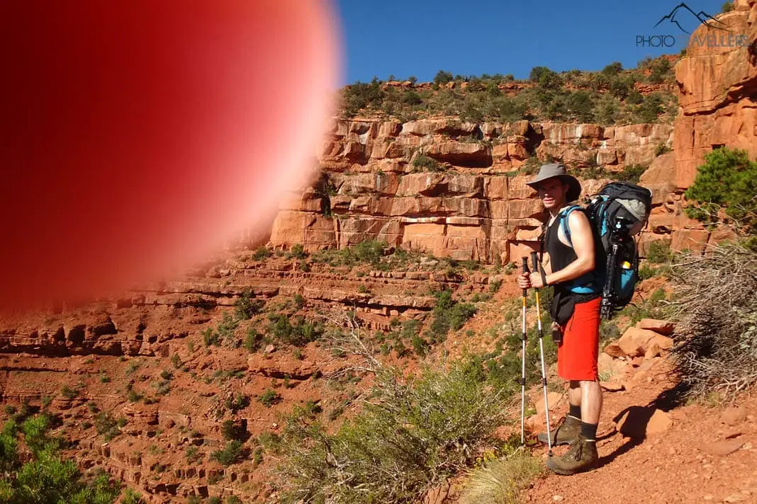 Flo mit einem großen Rucksack im Grand Canyon, wobei ein Finger ins Bild ragt