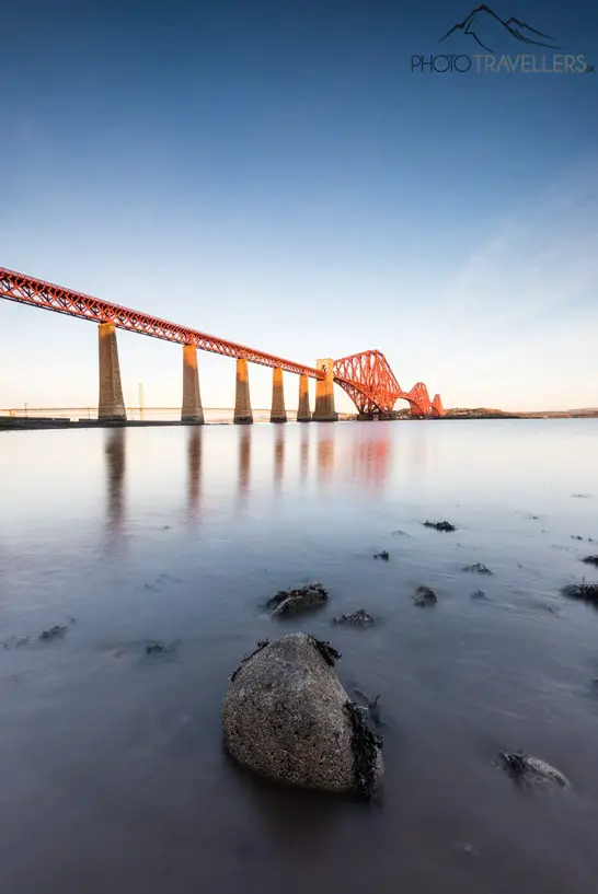 The Forth Bridge is illuminated by the rising sun