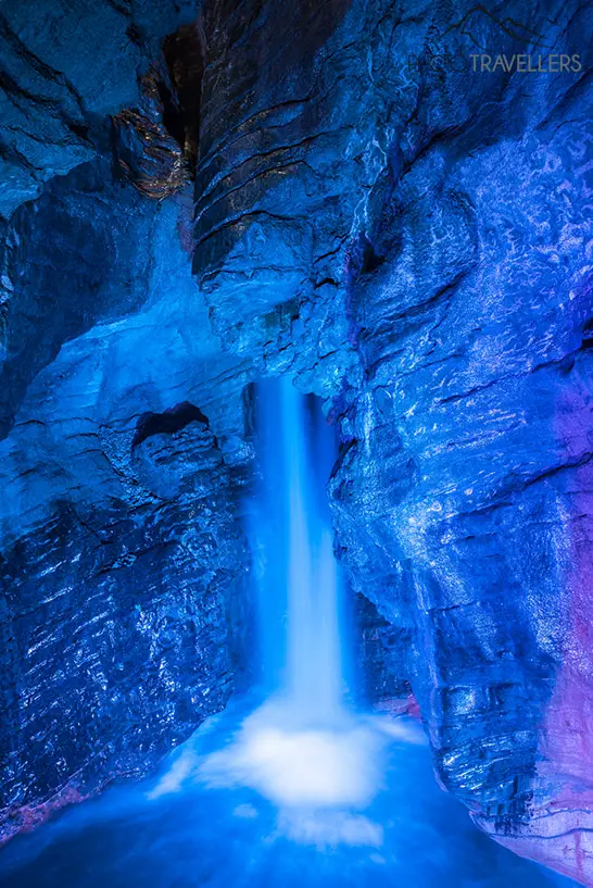 Der Varone Wasserfall, angestrahlt von blauem Licht in einer der Grotten