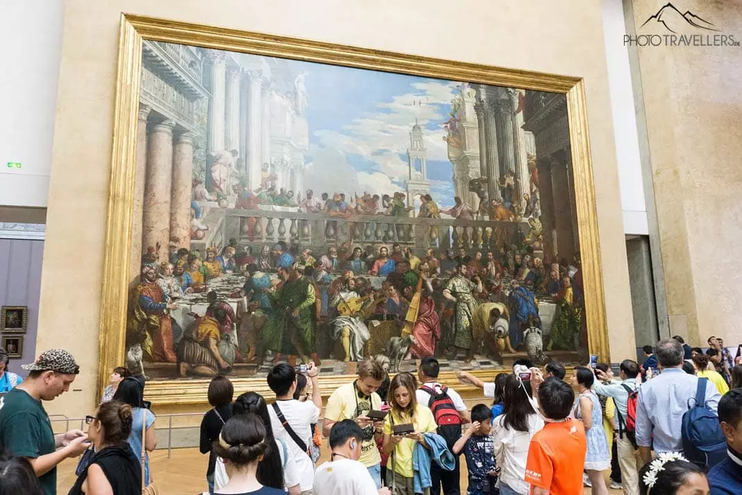 Crowds of people in front of paintings in the Louvre