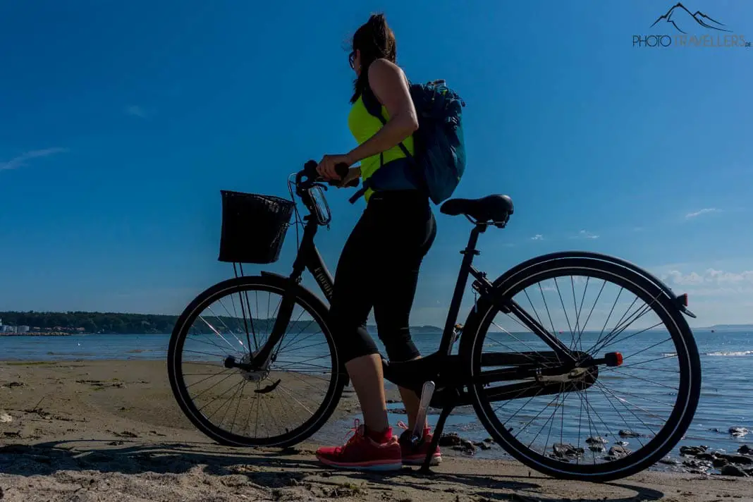 Frau mit Fahrrad am Strand