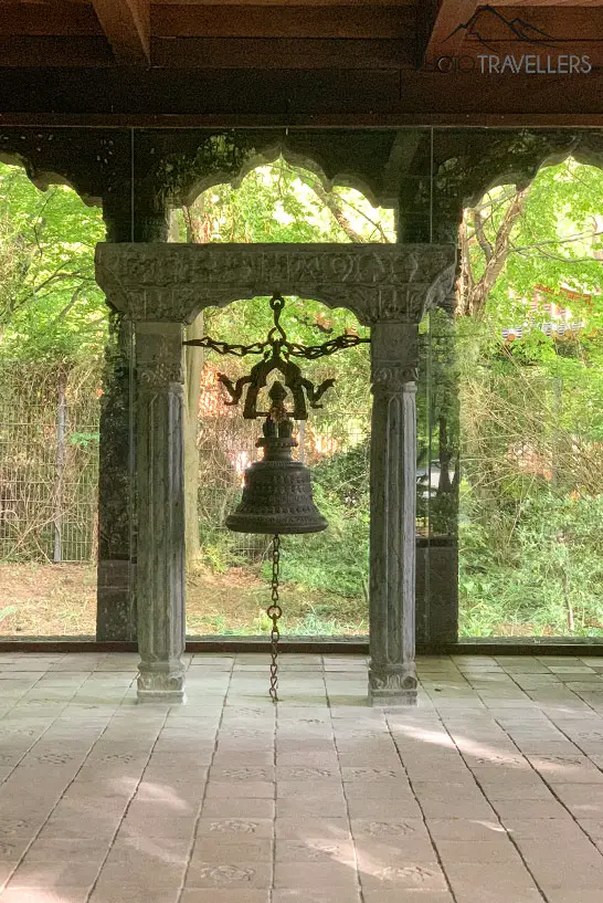 Eine Glocke hängt in einem Pavillion im Westpark am See