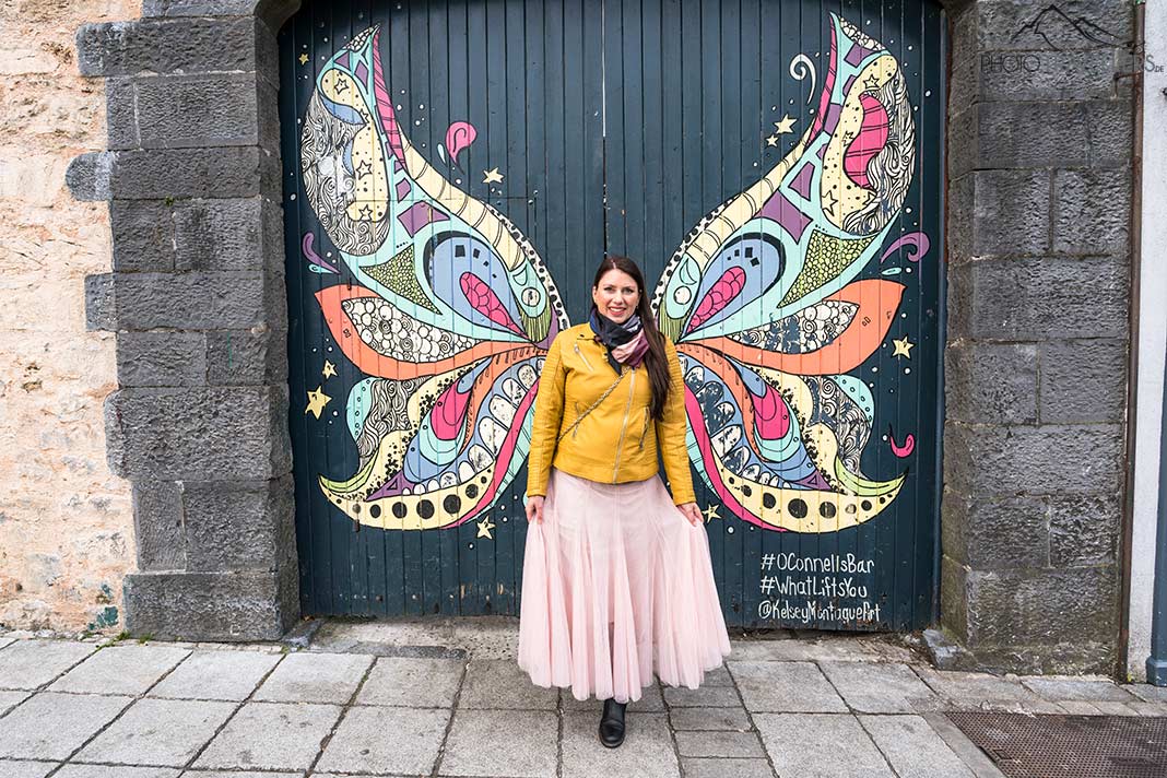 Reisejournalistin Biggi Bauer vor dem Engelsflügelmotiv vor dem O’Connor’s Famous Pub in Galway