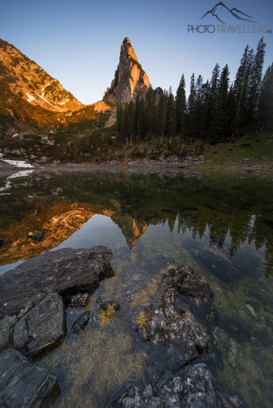 Ein spitzer Berg in Bayern, der sich am Morgen im See spiegelt, aufgenommen mit der Sony Alpha 7 IV