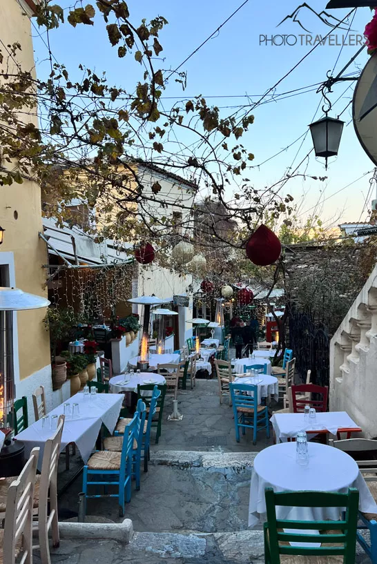 Tische und Stühle der Restaurants in der Gasse Mnisikleous im Viertel Plaka in Athen