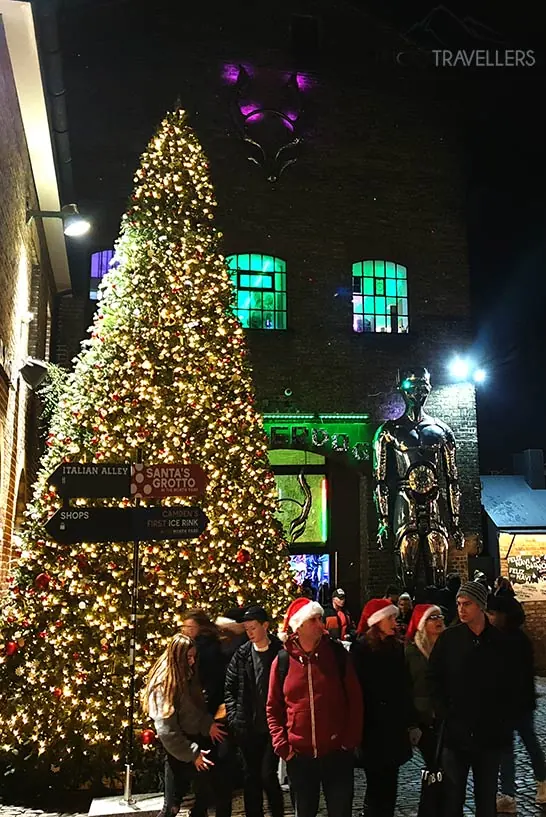 Menschen mit roten Weihnachtsmützen stehen neben einem großen Christbaum am Camden Market