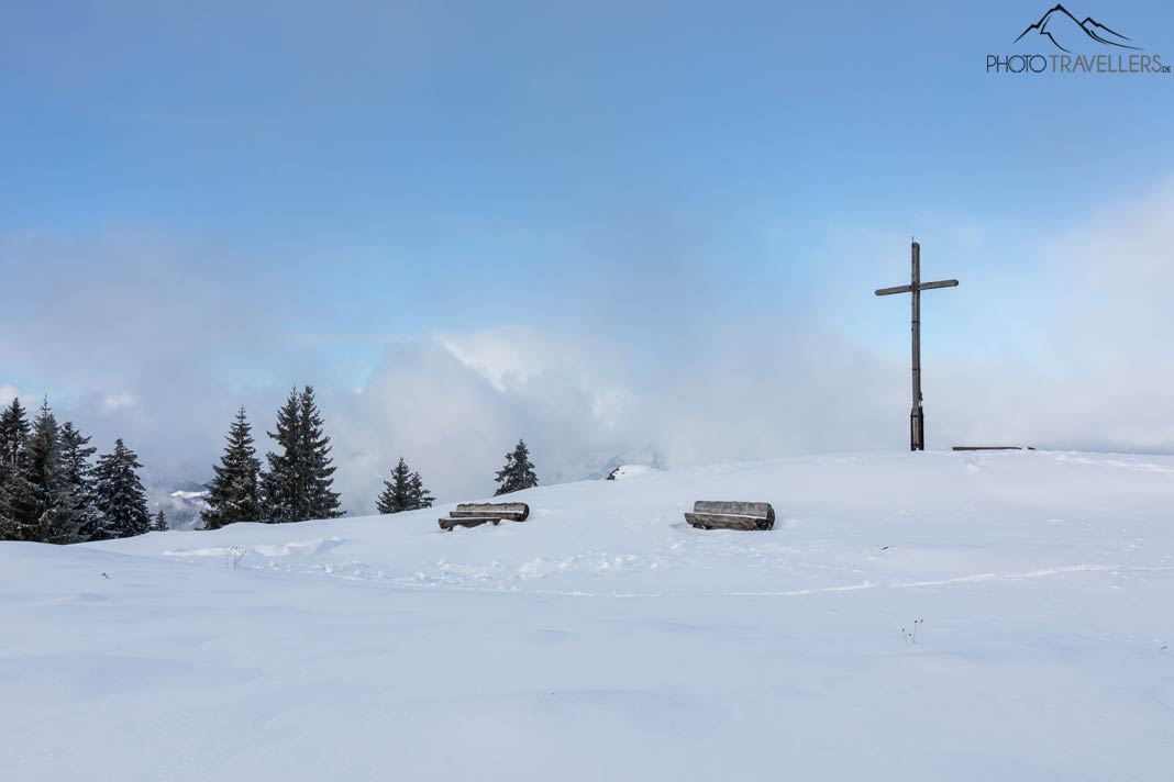 Das Gipfelplateau der Hochalm mit Gipfelkreuz und Holzbänken