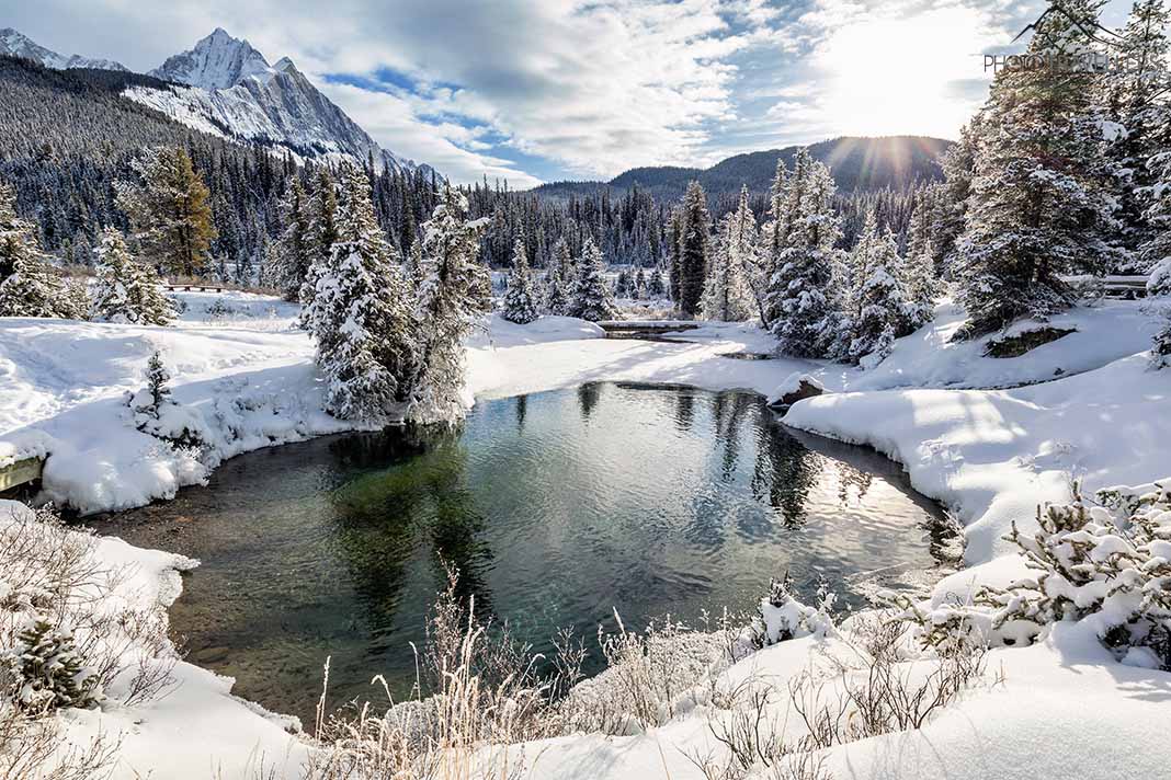Verschneite Landschaft mit offener Wasserstelle und dem Mount Ishbel