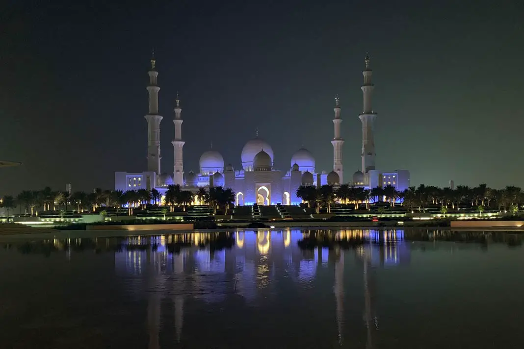 Die Sheikh Zayed Grand Mosque spiegelt sich im  Wasser