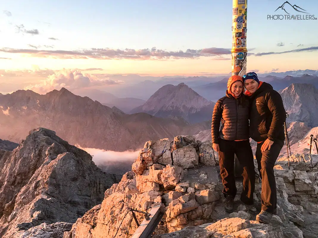 Die Reiseblogger Biggi Bauer und Florian Westermann am Gipfelkreuz der Zugspitze