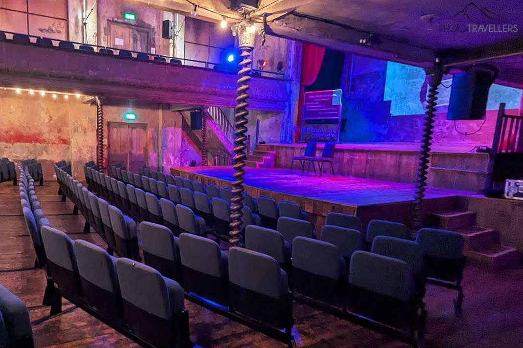 Leere Sitzreihen vor der bunt beleuchteten Bühne der Wilton's Music Hall
