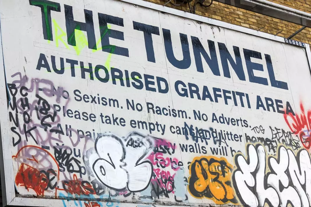 Street sign of the "The Tunnel" with a lot of graffiti on it