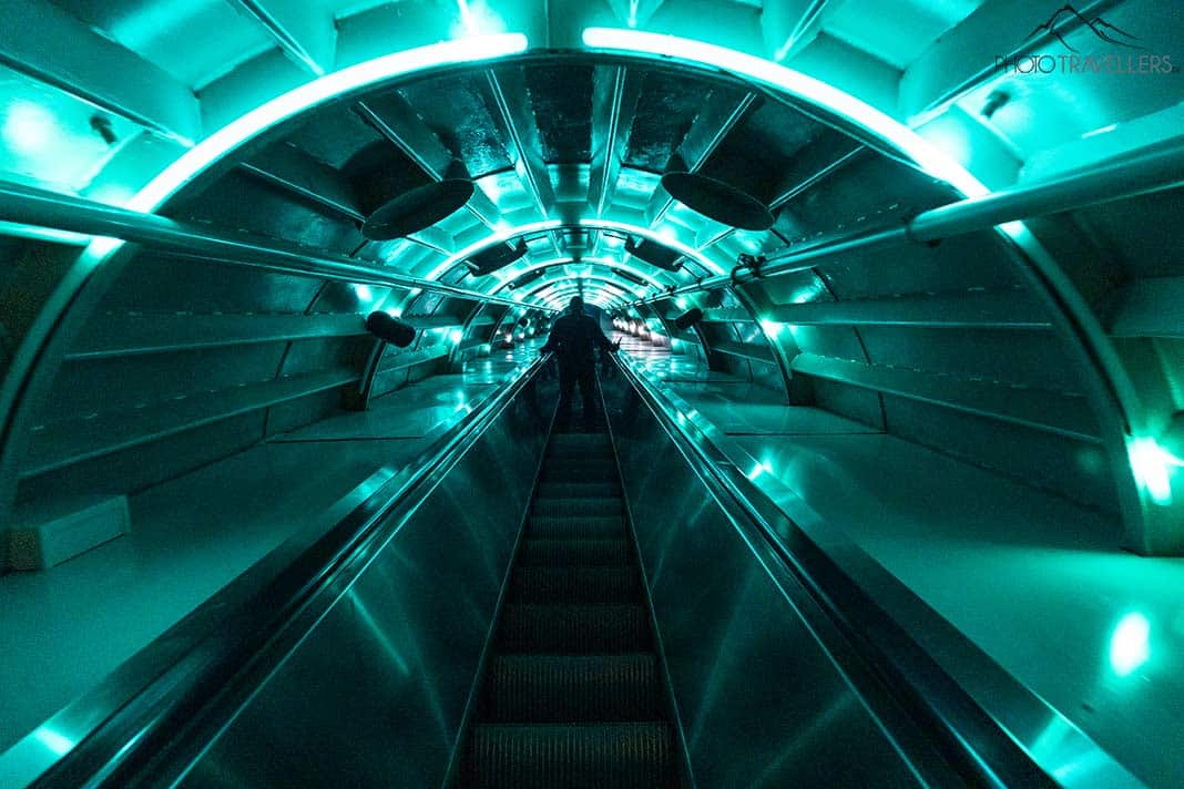 Eine lange Rolltreppe mit grüner Beleuchtung im Atomium in Brüssel