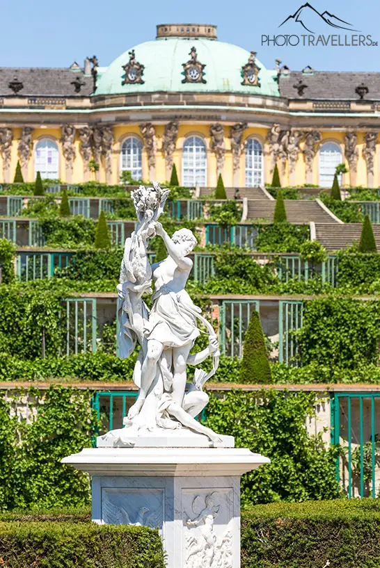 Die Statue einer Frau mit Schloss Sanssouci