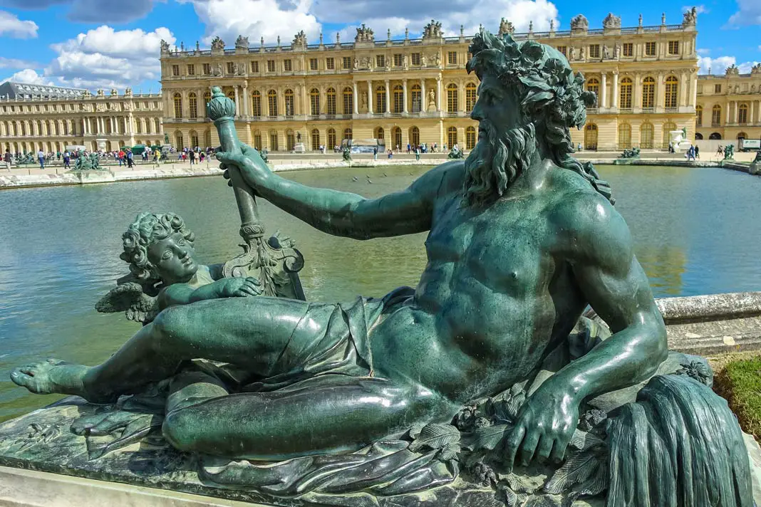 Eine Statue vor dem Schloss Versailles bei Paris