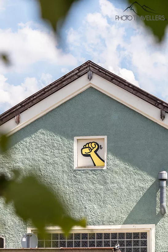 "Gelbe Faust"-Graffiti an einer Hauswand