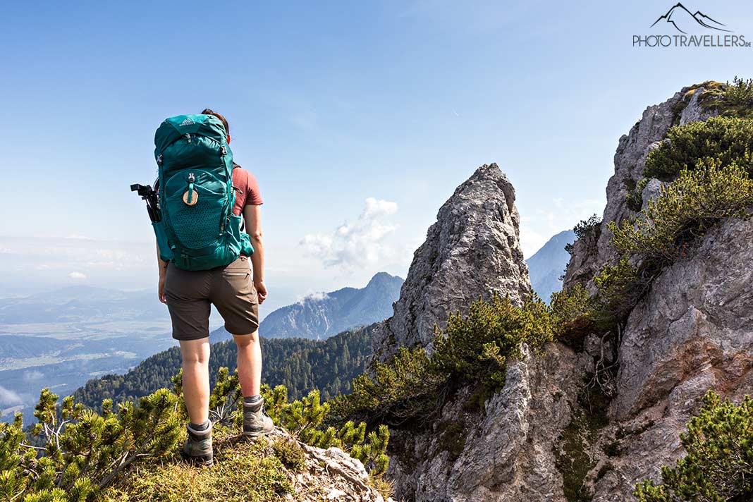 Reisebloggerin Biggi Bauer mit Rucksack im Gebirge, auf einem Teil des Alpe Adria Trails