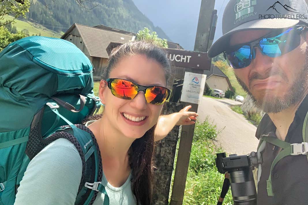 Die Reiseblogger Biggi Bauer und Florian Westermann an einem Umleitungsschild einer Fernwanderung
