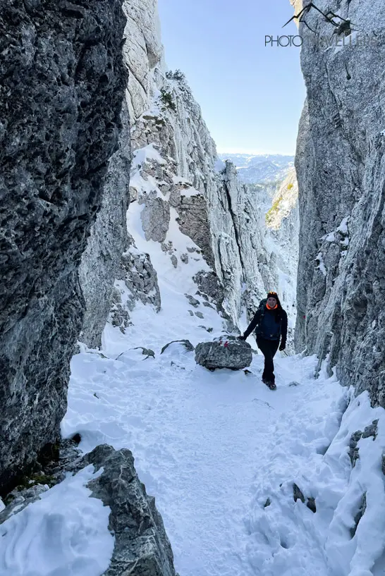 Biggi im Winter zwischen zwei Felswänden auf dem Weg zur Kampenwand