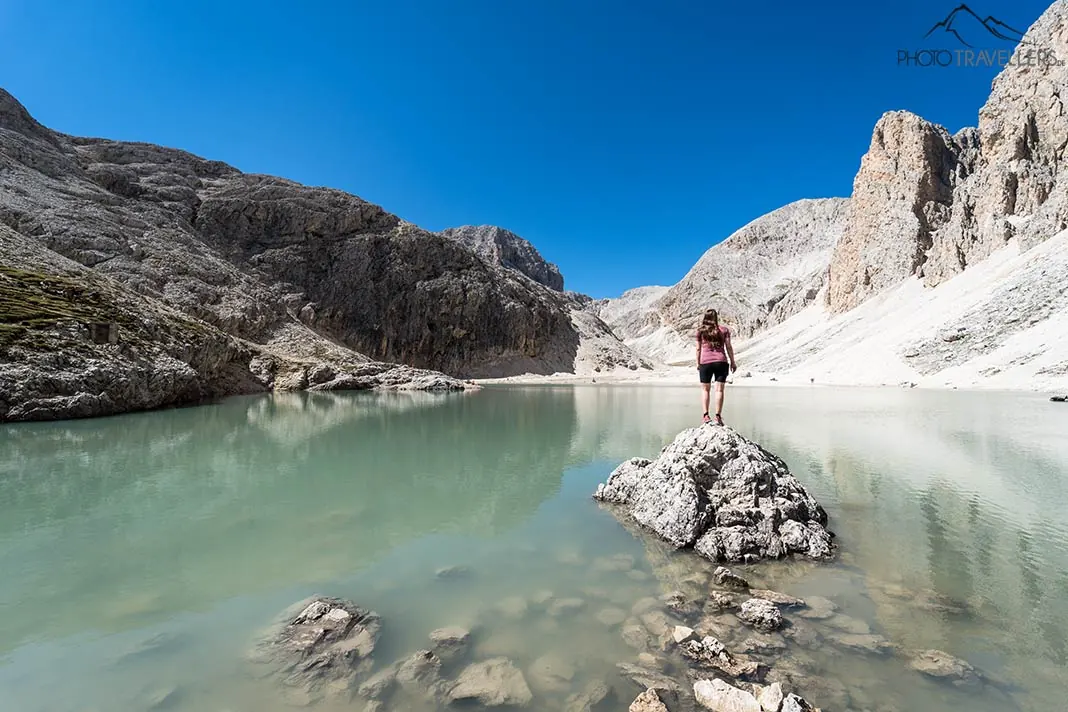 Reisebloggerin Biggi Bauer auf einem Fels im Lago di Antermoia