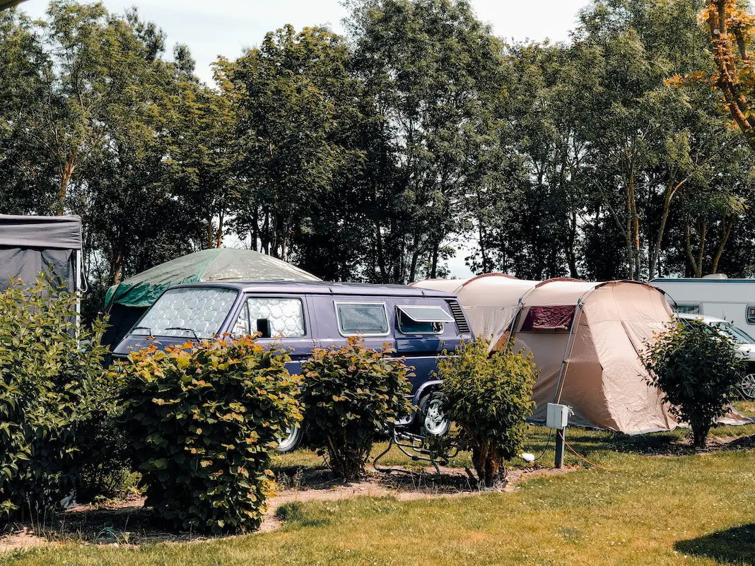 Camper mit separatem Zelt auf Campingplatz