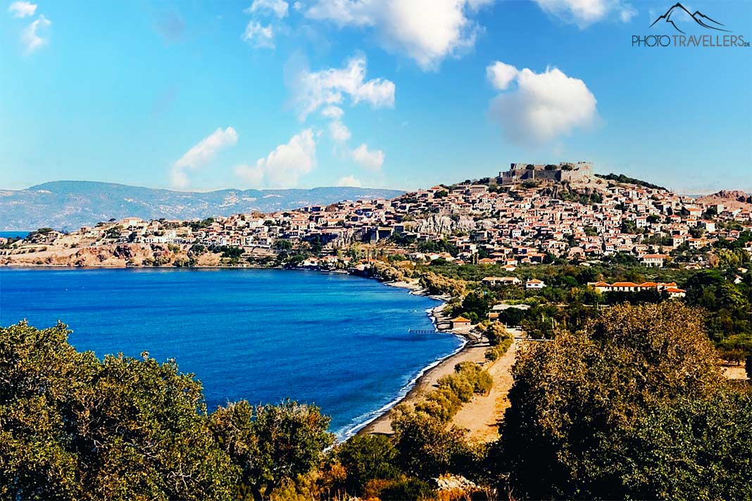 Die Steinhäuser von Molyvos reihen sich unterhalb der Burg eng aneinander, im Vordergrund die Bäume in der Bucht von Molyvos