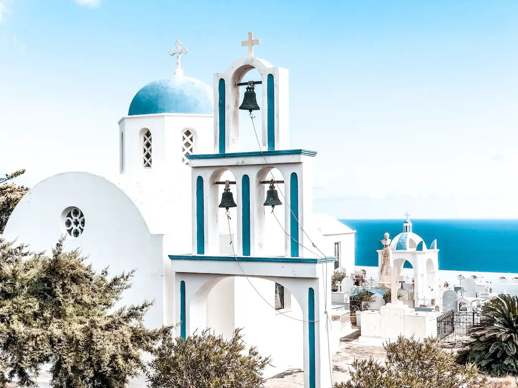 Eine blau-weiße Kirche auf Santorini mit Blick aufs Meer