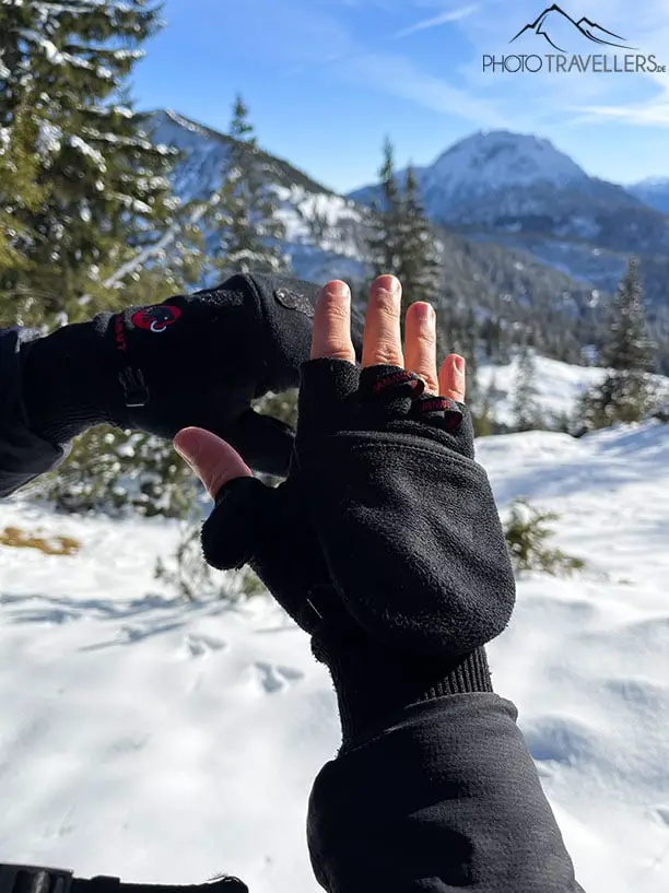 Ein Fotohandschuh vor einer Bergkulisse im Winter
