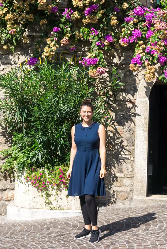 Reisebloggerin Biggi Bauer vor einer Blütenwand in Sirmione