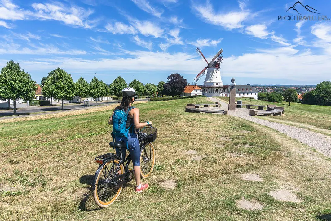 Reisebloggerin Biggi Bauer auf dem Fahrrad vor einer Windmühle in Dänemark