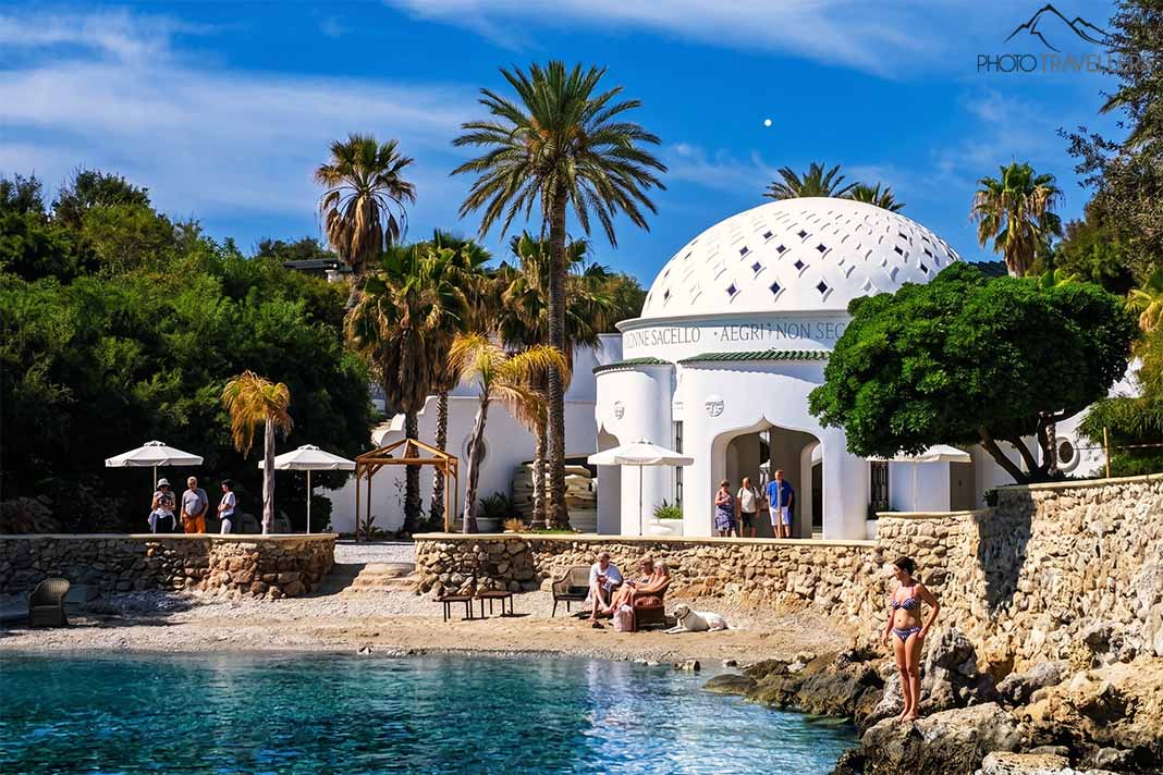 Ein weißer Pavillon an der Therme von Kallithea mit wenigen Menschen an der Bucht