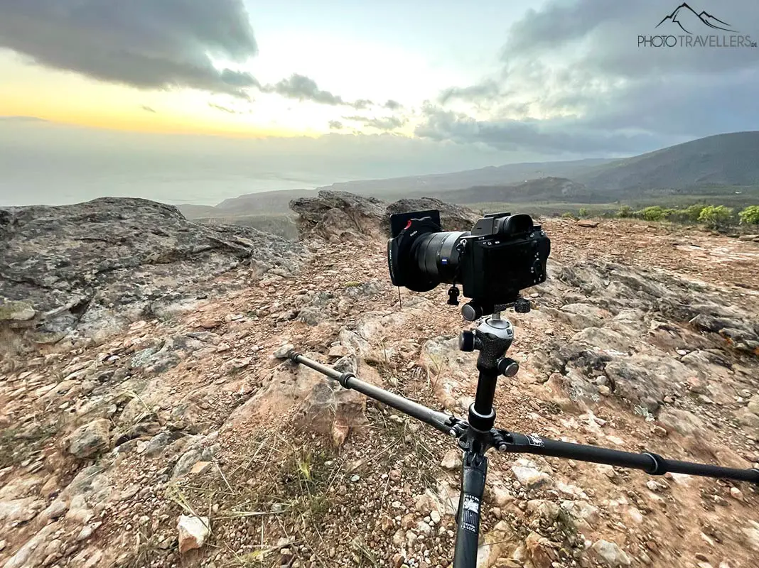 Eine Sony-Alpha-Kamera auf einem Gitzo-Reisestativ auf einem Berggipfel am Abend