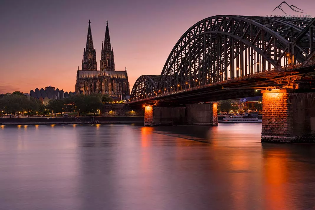 Der Kölner Dom mit der Hohenzollernbrücke im Dämmerlicht am Abend