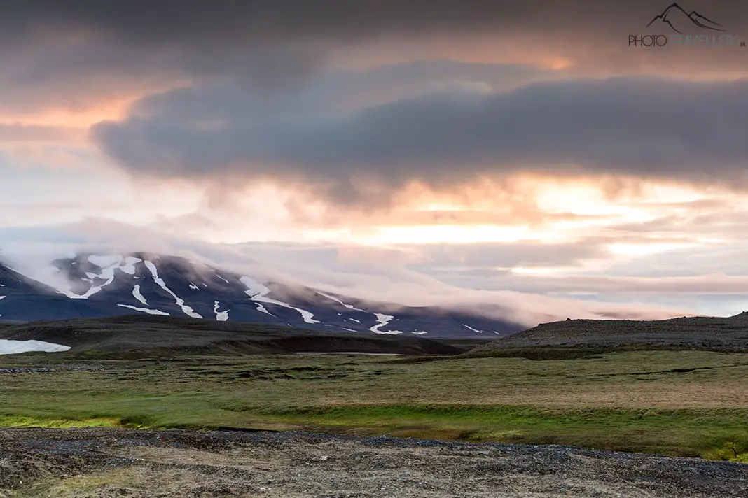 Ein glühender Himmel über Bergen auf Island